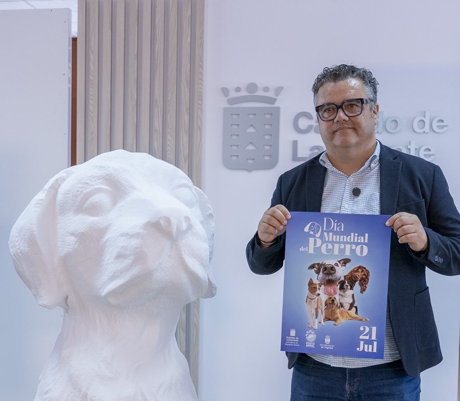 Armando Santana, consejero de Bienestar Animal del Cabildo, presenta el cartel de la Semana del Día Internacional del Perro junto a una escultura canina / Foto: Cabildo de Lanzarote